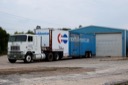 a white and blue truck in front of a blue building
